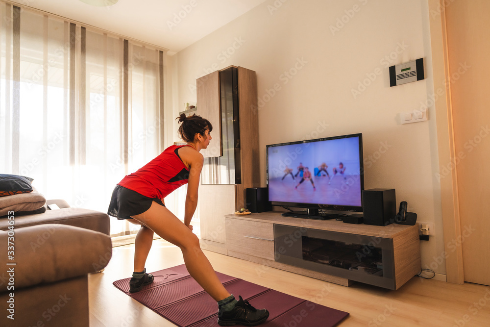 Stretches in the room following the instructions of the online teacher. Sport in the covid19 quarantine at home Stretches in the room following the instructions of the online teacher. Sport in the covid19 quarantine at home