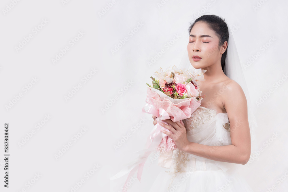Naklejka premium Asian woman is wearing wedding dress with free space on white background