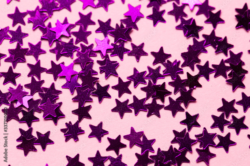 Closeup asterisks sprinkled on a pink isolated background. View from above.