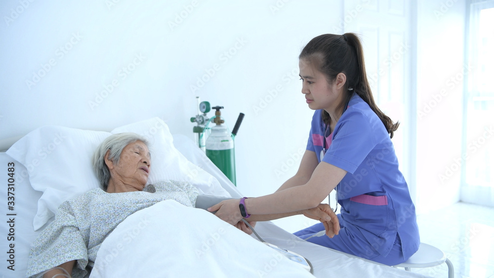 Obraz premium Medical concepts. Young nurse measuring the pressure of elderly patients in the hospital. 4k Resolution.