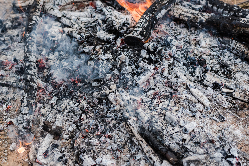 Burning coals in a fire with orange flames. Ashes. Burning coals in a fire with orange flames. Ashes.