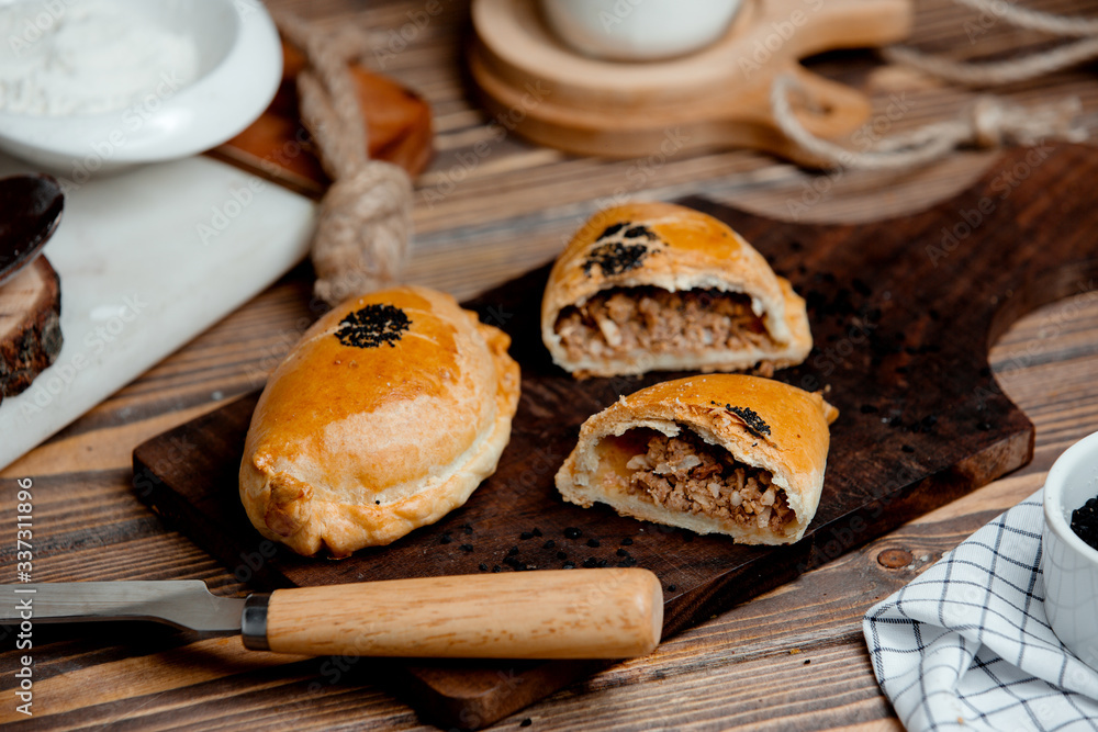 meat pies from bougie dough on a wooden board meat pies from bougie dough on a wooden board