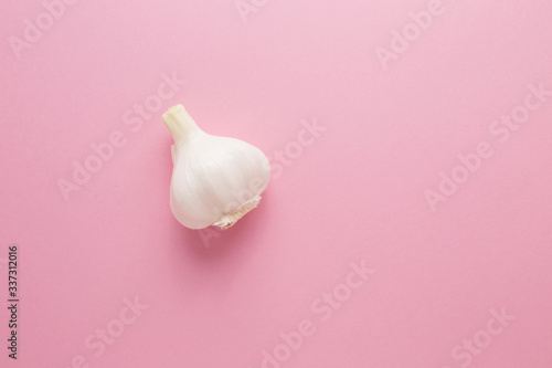 Garlic on a pink background close-up. Prevention of virus diseases.