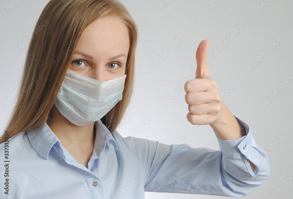 young woman shows thumb up with medical mask young woman shows thumb up with medical mask