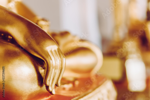 Background buddha face head body hands in buddhist temple with isolated wall. Thai old woman pray for good luck, zen peaceful and holy meditation relax. Gold statue in Thailand temple to worship