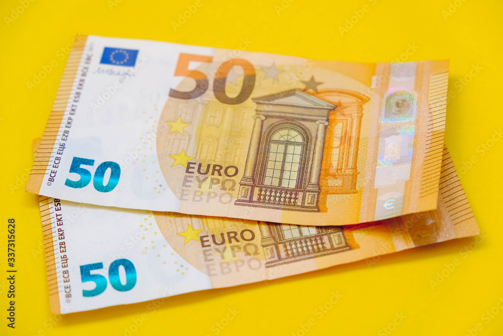 Euro banknotes on a yellow background. Copy, empty space for text Euro banknotes on a yellow background. Copy, empty space for text