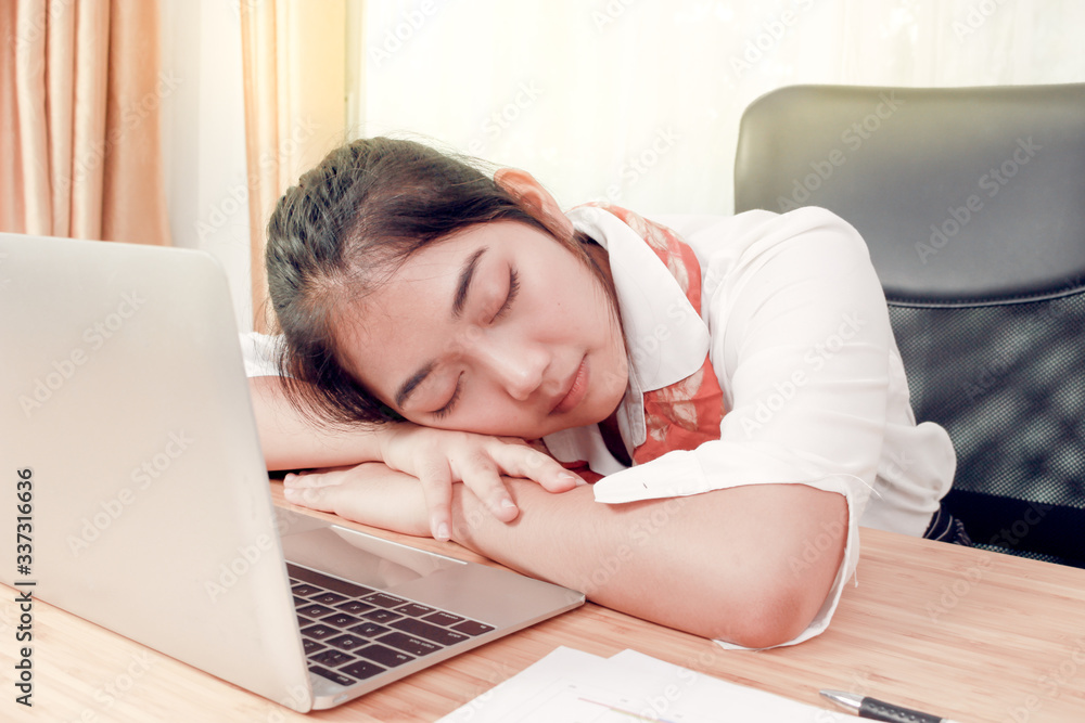 Tired Asian business woman taking a nap on messy desk in office after work hard long time. Sleepy employee officer sleeping for relaxing. Tired Asian business woman taking a nap on messy desk in office after work hard long time. Sleepy employee officer sleeping for relaxing.