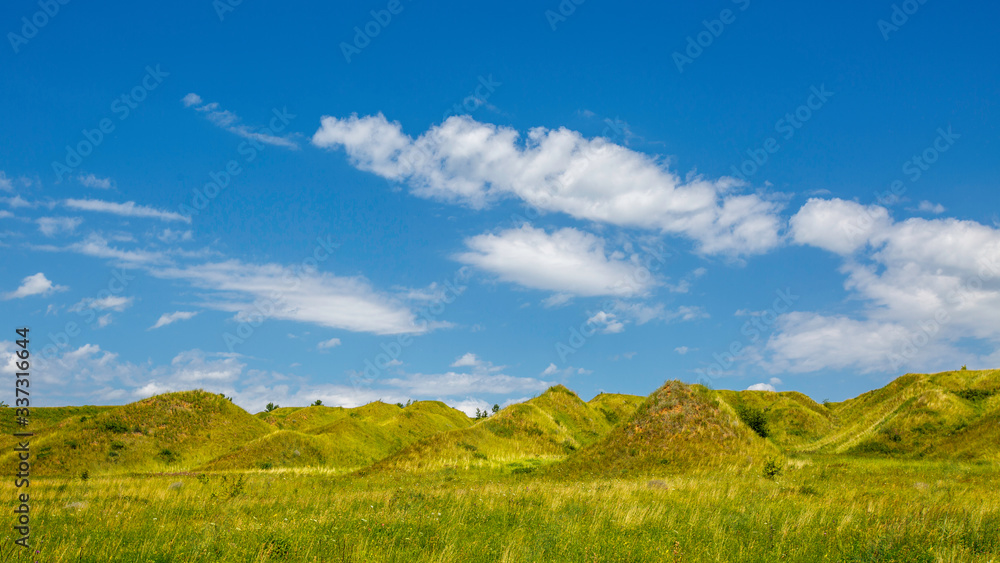 grass-covered hills above the valley on a sunny day grass-covered hills above the valley on a sunny day