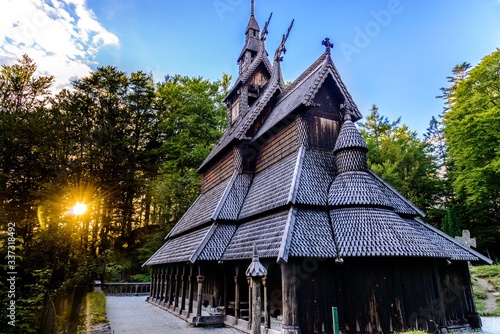 Fantoft Stave Church (Stavkirke, stavkyrkje) at sunset with a sun in Bergen, Norway.