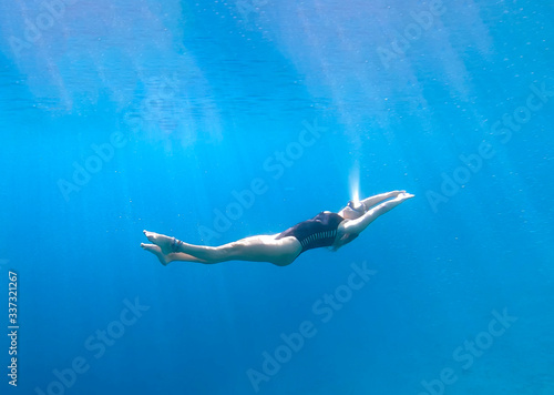 Free Diver girl floating under the water in the Red Sea
