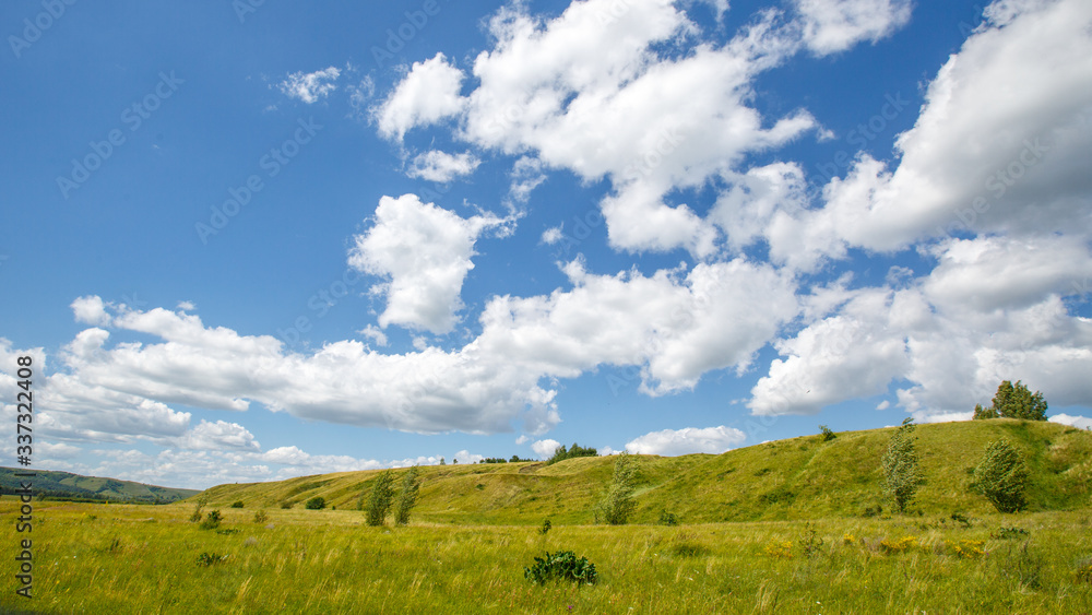 grass-covered hills above the valley on a sunny day grass-covered hills above the valley on a sunny day