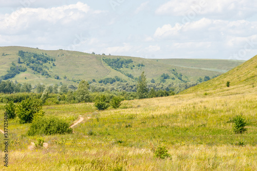 valley, meadow between hills with dirt country road © Андрей Пугачев
