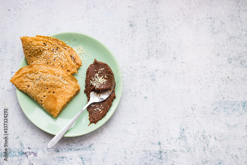 Crepes or thin pancakes on plate with chocolate homemade hazelnut paste spread. Copy space.