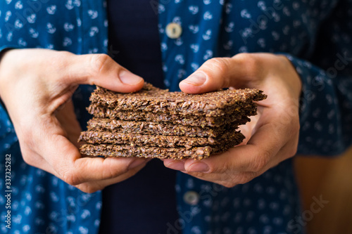 Woman holds flax flatbreads in hands. Dehydrated low fat food. Dieting bread.