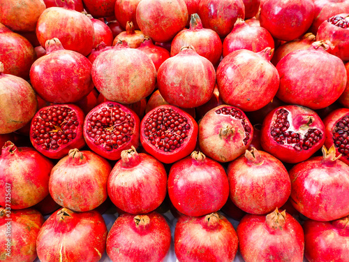 Ripe red pomegranates are displayed in a row. Fruit background.