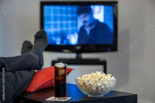 man playing game with foot over the table with popcorn and soda