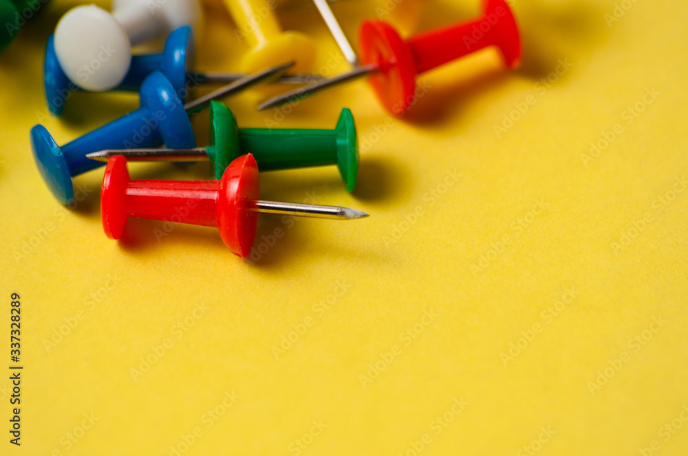 Thumbtacks of different colors on yellow background close-up macro copy space Thumbtacks of different colors on yellow background close-up macro copy space