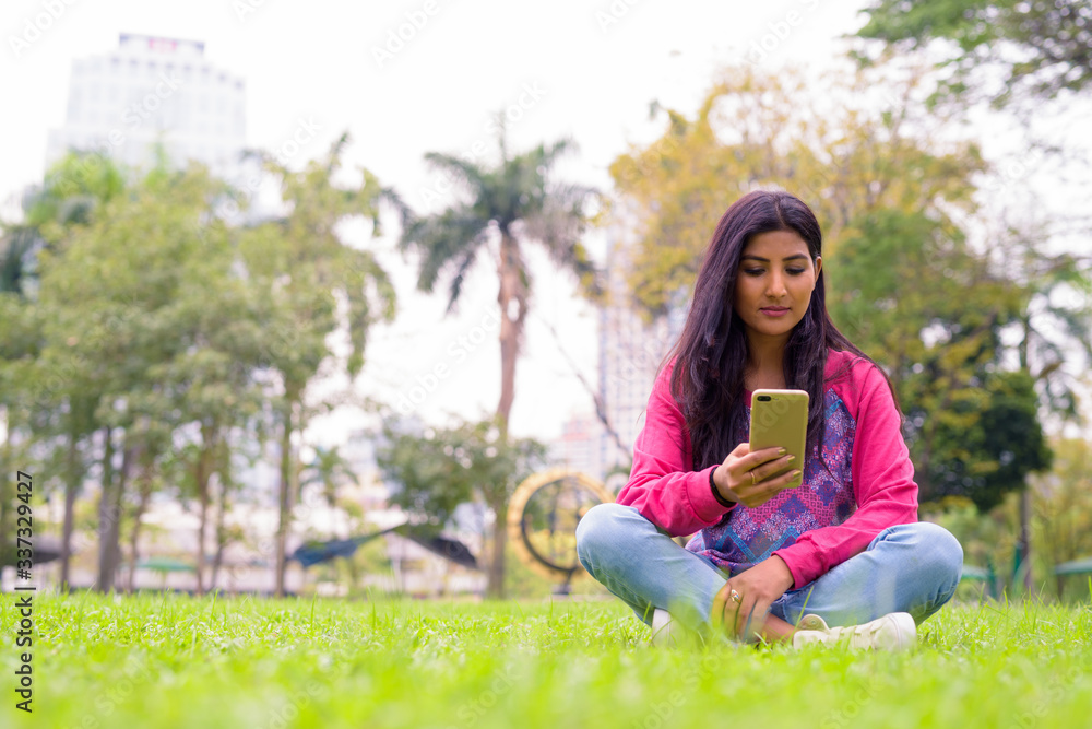 Young beautiful Persian woman using phone at the park Young beautiful Persian woman using phone at the park