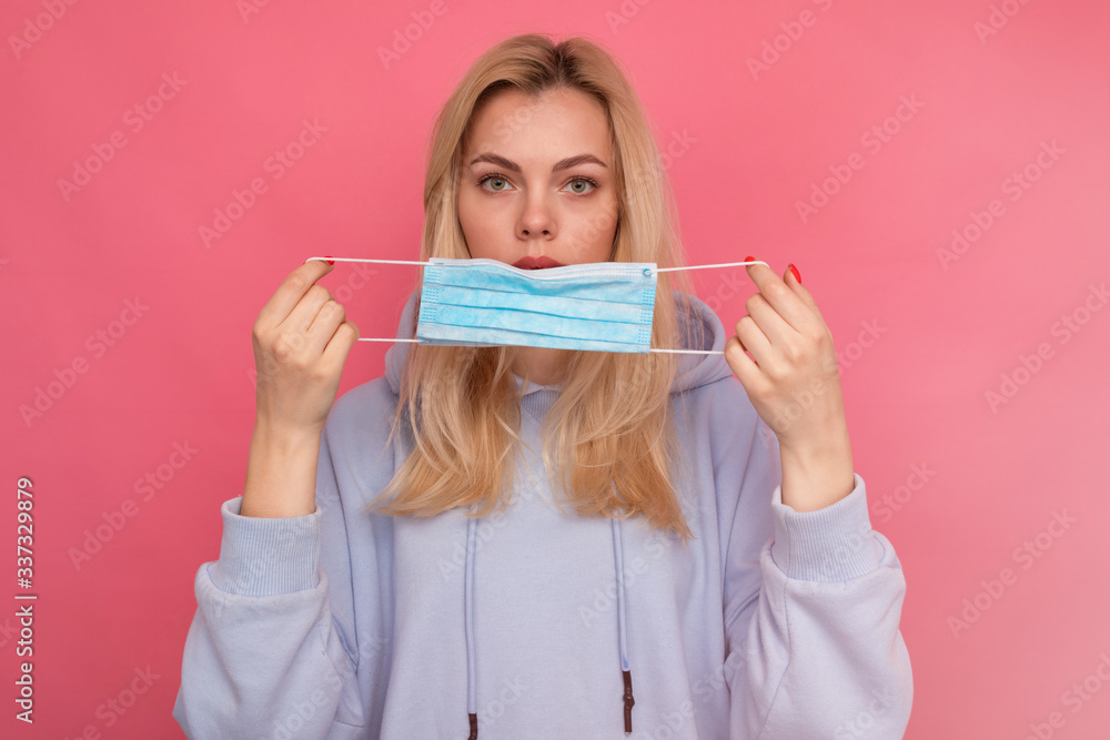 A young girl puts on a blue protective mask. Viral infection A young girl puts on a blue protective mask. Viral infection