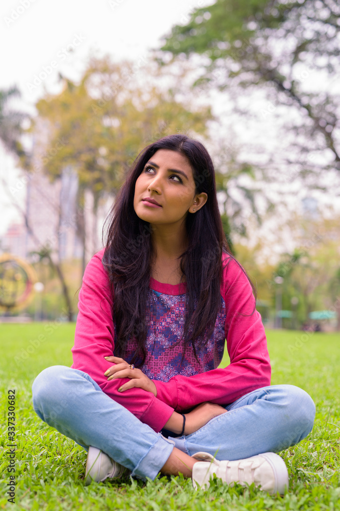 Young beautiful Persian woman thinking at the park Young beautiful Persian woman thinking at the park