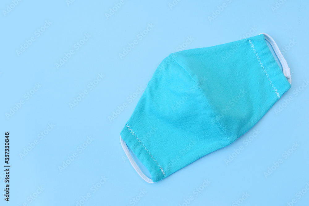 Protective turquoise face virus mask nurse on blue paper background with place for your text. Coronavirus Protection