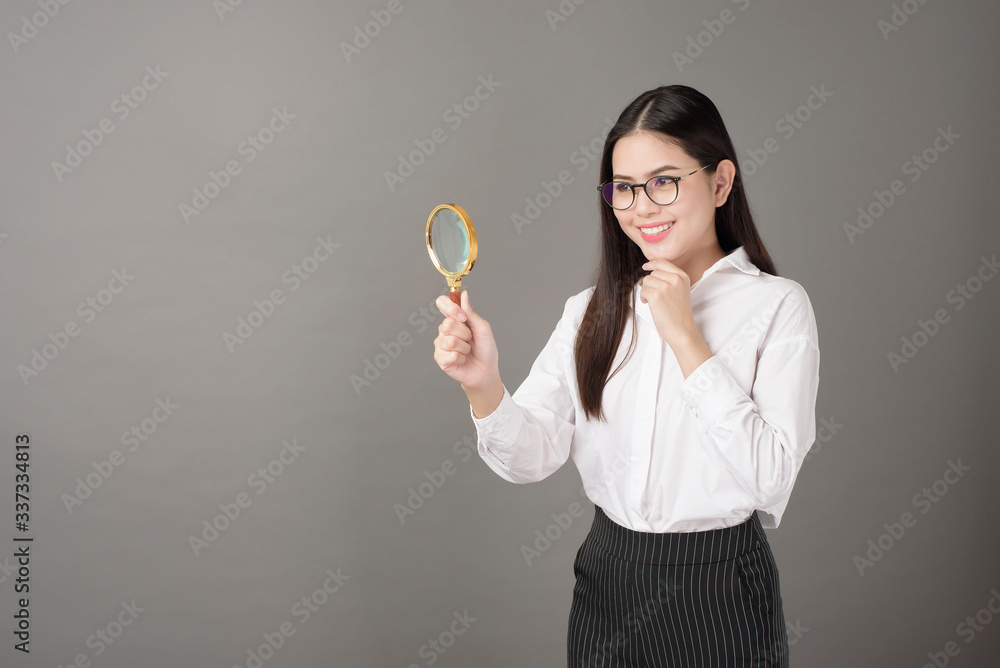 Beautiful woman is holding magnifying glass in studio Beautiful woman is holding magnifying glass in studio