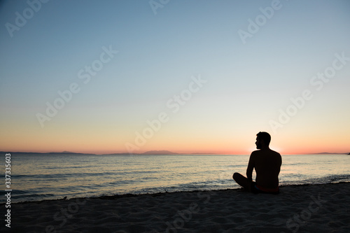 Young man enjoying sunset on the beach