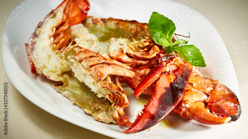 a luxury dish of lobster roasted and decorated with lemon and basil. Shallow dof