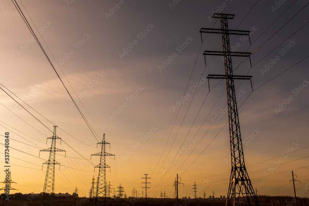 high-voltage power lines at sunset. electricity distribution station