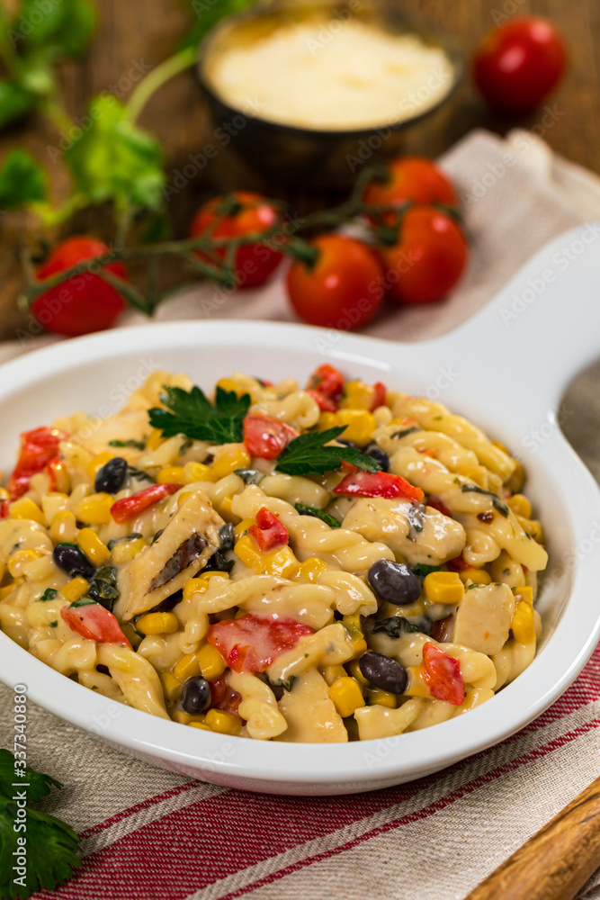 Grilled Chicken Alfredo Pasta with Black Beans, Corn and Red Peppers on Wooden Background. Selective focus. Grilled Chicken Alfredo Pasta with Black Beans, Corn and Red Peppers on Wooden Background. Selective focus.