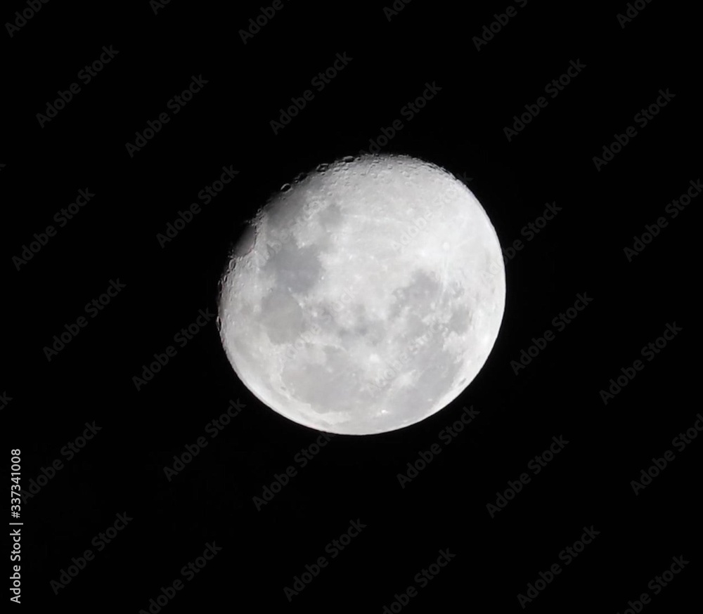 Fototapeta premium Bright moon highlighting the deep craters taken over Sydney NSW Australia on a dark cloudy night 