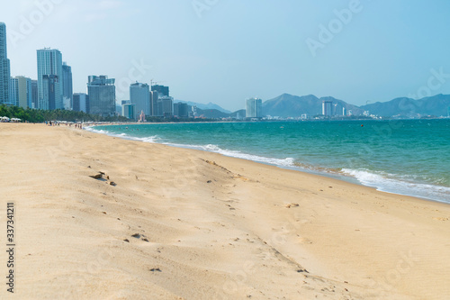 Empty sandy beach and sea waves with hotels on the beach on a sunny day © Евгений Дубасов