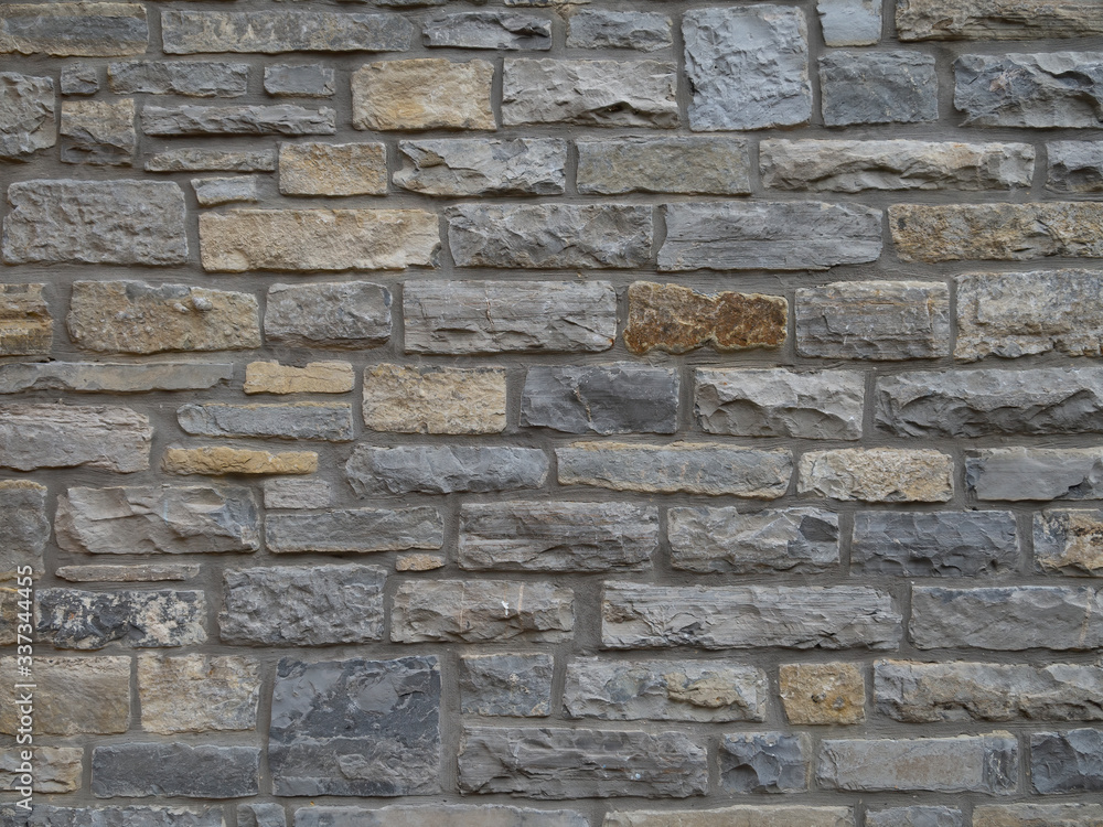 Traditional local stone house wall in Street, Somerset, England. Maybe blue lias. Old.