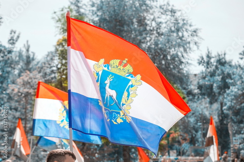 Flags of the Samara region fluttering against the blue sky photo