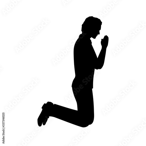 Silhouette of man kneeling praying