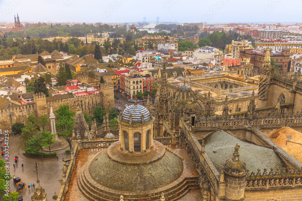 Aerial view of Seville skyline, Seville Cathedral of Saint Mary of the See from Giralda tower,  Triumph square and walls and buildings of Royal Alcazar. Seville, Andalusia, Spain.