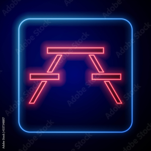 Glowing neon Picnic table with benches on either side of the table icon isolated on blue background. Vector Illustration