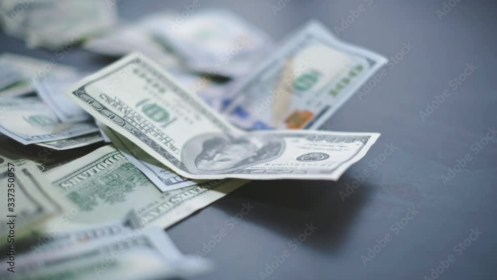 Falling Dollar banknotes. High quality falling Dollar banknotes. Many American dollars are slowly falling onto the table. Man throws green american money. American financial system. Falling Dollar banknotes. High quality falling Dollar banknotes. Many American dollars are slowly falling onto the table. Man throws green american money. American financial system.