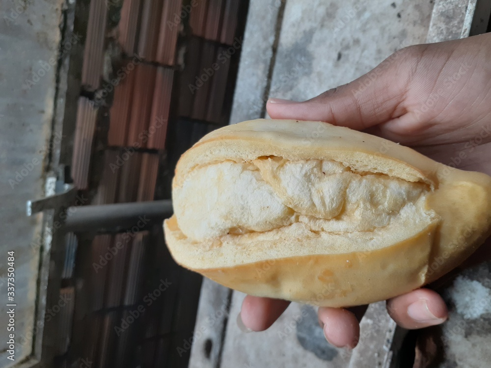 hand holding a loaf of bread hand holding a loaf of bread