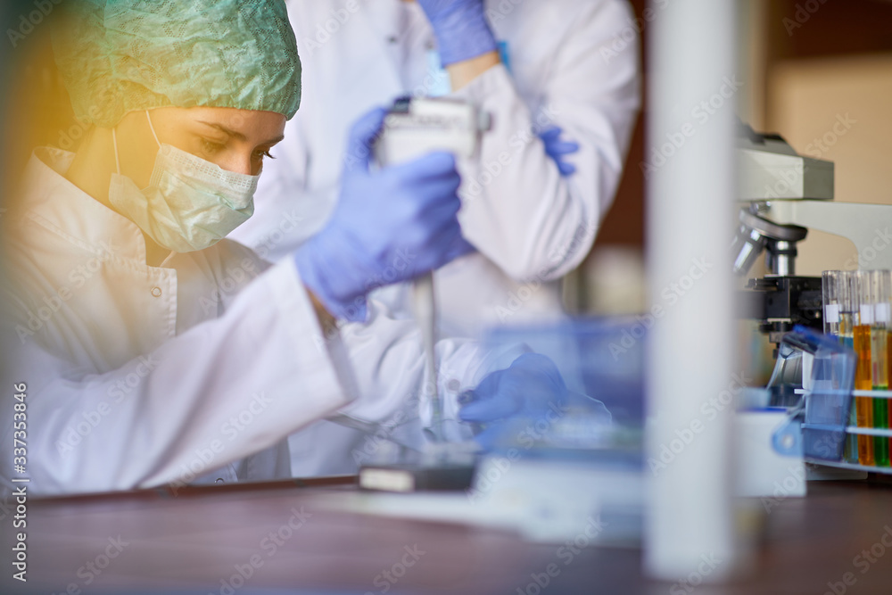 Lab technician examining blood sample on corona virus Lab technician examining blood sample on corona virus