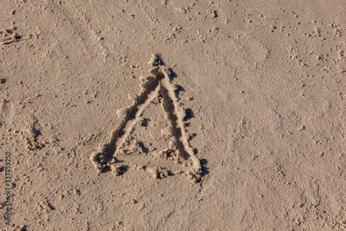 triangle drawn on beach sand
