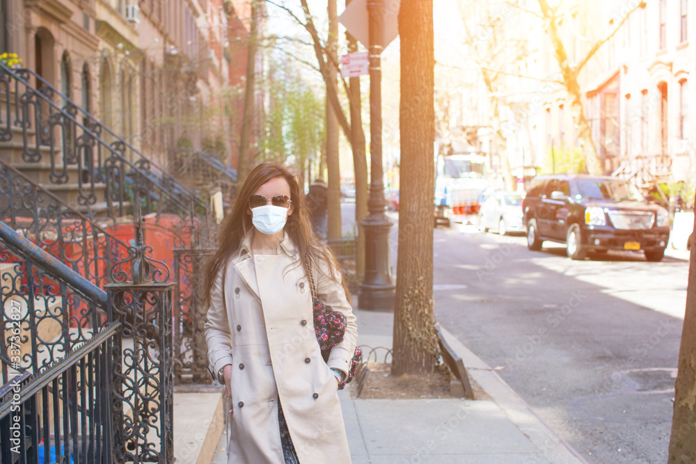 Young woman walks in empty New York in a mask protecting from the virus