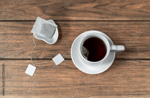 una taza de té caliente con una bolsa de té sobre una mesa de madera vista desde arriba photo