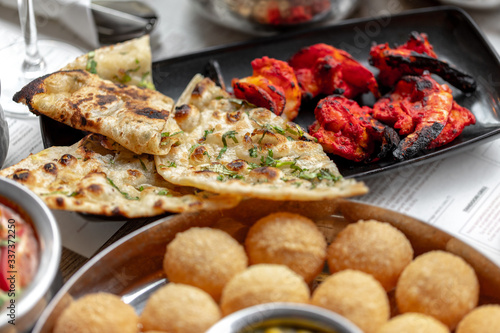 tandoori shrimp baked in the oven, traditional Indian dish served with naan bread