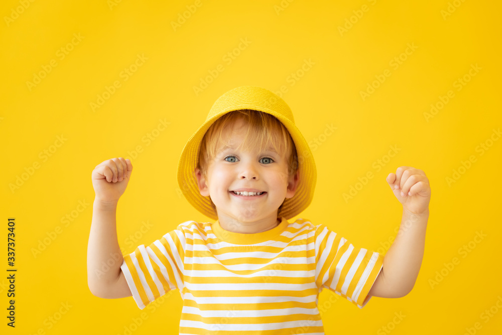 Portrait of happy child against yellow background. Summer vacation concept Portrait of happy child against yellow background. Summer vacation concept