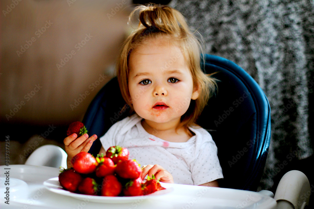 little girl eating strawberries at home little girl eating strawberries at home