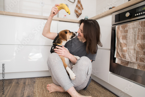 girl with a cute dog sits on the floor in the kitchen