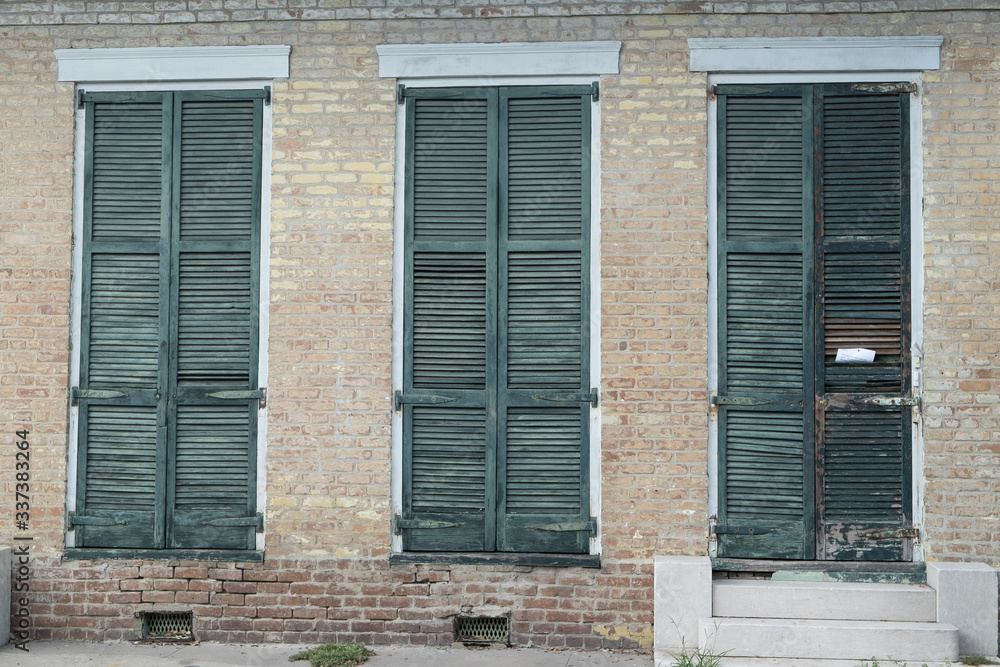 Three shuttered windows on brick wall Three shuttered windows on brick wall