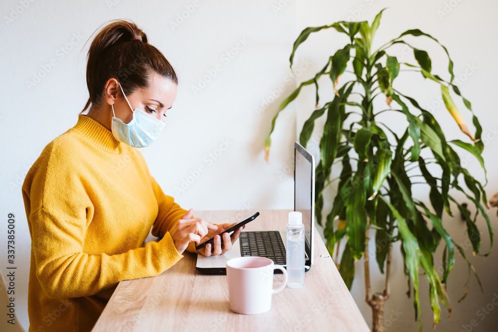 young woman working on laptop at home, wearing protective mask. work from home, stay safe during coronavirus covid-2019 concpt young woman working on laptop at home, wearing protective mask. work from home, stay safe during coronavirus covid-2019 concpt