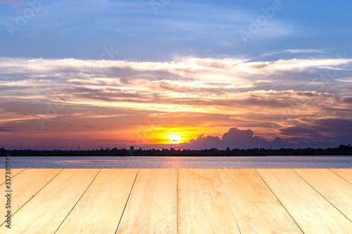 Wooden plank on lake during sunset background. © Pituk